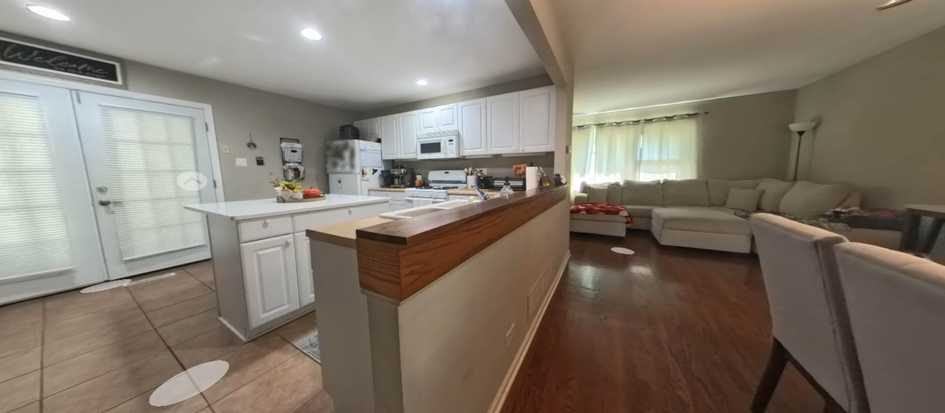 Wide view of a bright kitchen and connected living area